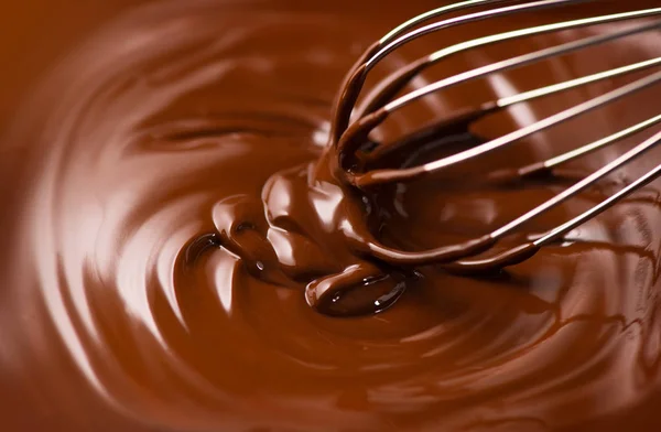 Chocolate. Mixing melted dark chocolate with a whisk. Closeup of — Stock Photo, Image