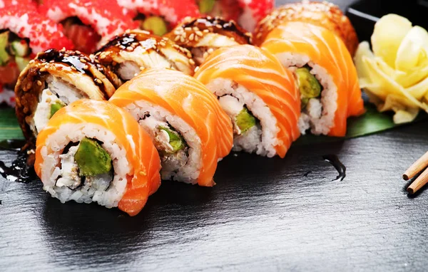 寿司はクローズアップをロールします レストランで日本食 黒いスレートの背景にサーモン ウナギ 飛ぶ魚のキャビアとロール — ストック写真