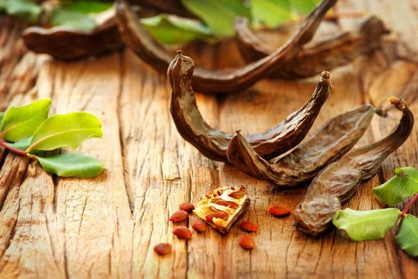 Carob. Healthy organic sweet carob pods with seeds and leaves on Stock Image