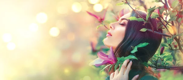 Menina bonita feliz desfrutando da natureza. Magnólia florescente. Beleza Imagem De Stock