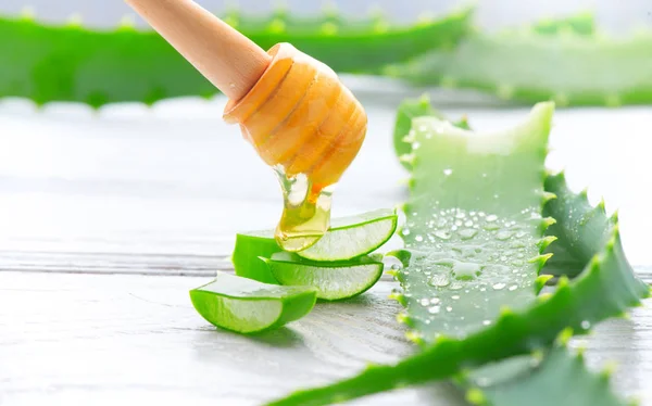 Aloe Vera with honey closeup on white wooden background. Sliced — Stock Photo, Image