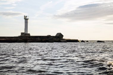 Deniz feneri ve akşam dalgalarda. Riga, Letonya 