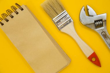 Onarım ve yenileme kavramı. Fırçalar, tornavida, sarı arka plan üstten görünüm, düz yatıyordu, eldiven ile onarım için araçlar kümesi kopyalama alanı