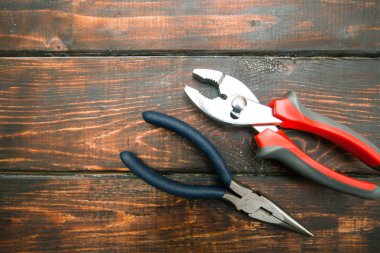 Onarım modern araçlar: pense üstten görünüm, koyu ahşap arka plan üzerinde kopyalama alanı