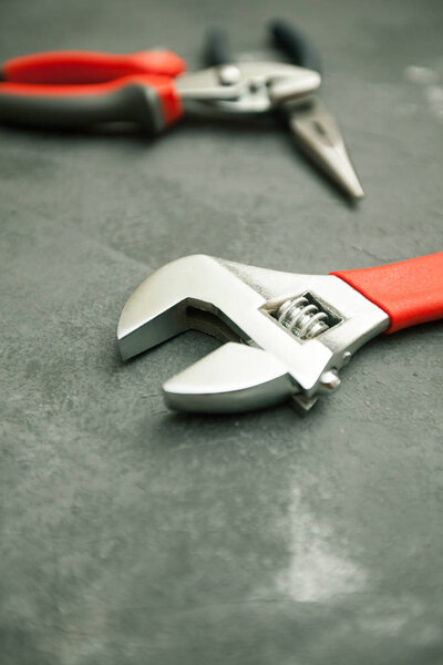 Repair modern tools: pliers on dark stone background, top view, copy space