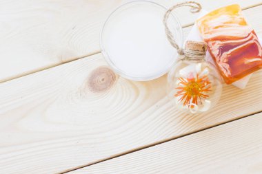 Spa ve sağlıklı yaşam ayarı sarı çiçekli petrol ve ahşap beyaz arka plan closeup sabun |