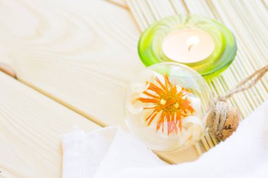 Spa ve sağlıklı yaşam ayarı sarı çiçek, yeşil mum, yağ ve sabun ahşap beyaz arka plan üzerinde