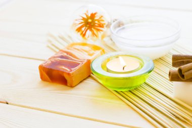 Spa ve sağlık ayar sarı çiçek, yeşil mum, yağ, tarçın ve soap ahşap beyaz arka plan üzerinde