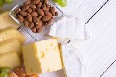 Aperatifler - peynir, incir, fındık, tatlım, bir ahşap kurulları zemin üzerine üzüm türleri ile şarap. Üstten görünüm