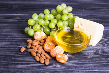 Peynir incir, fındık, bal, üzüm ile bir karanlık rustik ahşap Komiteler arka plan üzerinde keser. Üstten görünüm