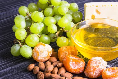 Peynir incir, fındık, bal, üzüm ile bir karanlık rustik ahşap Komiteler arka plan üzerinde keser. Üstten görünüm