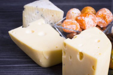 Peynir incir, fındık, bal, üzüm ile bir karanlık rustik ahşap Komiteler arka plan üzerinde keser. Üstten görünüm