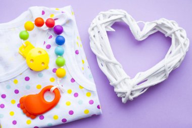 Sarı Bebek Patikleri. Çocuk ayakkabı ve oyuncaklar mor zemin üzerine. Yeni doğan. Üstten görünüm