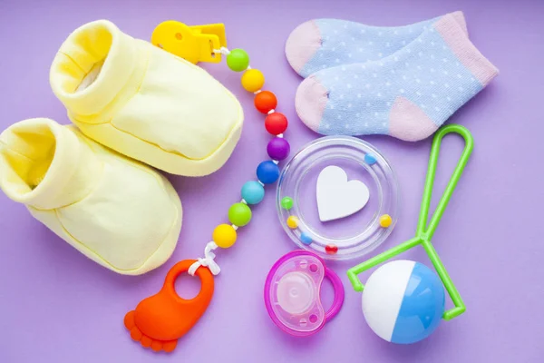 Gele Baby Laarsjes Kinder Schoenen Speelgoed Paarse Achtergrond Pasgeborene Bovenaanzicht — Stockfoto