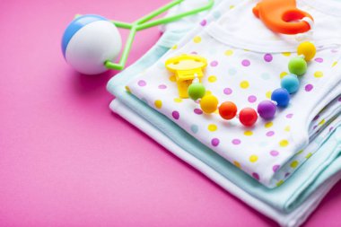 Sarı Bebek Patikleri. Çocuk ayakkabı ve pembe bir arka plan üzerinde oyuncaklar. Yeni doğan. Üstten görünüm