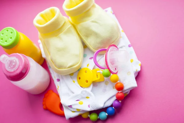 Gele Baby Laarsjes Kinder Schoenen Speelgoed Roze Achtergrond Pasgeborene Bovenaanzicht — Stockfoto
