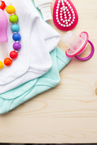 Baby yellow booties. Children's shoes and toys on white wooden boards background. Newborn. Top view