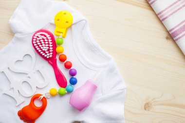 Sarı Bebek Patikleri. Çocuk ayakkabı ve beyaz ahşap tahtalar arka plan üzerinde oyuncaklar. Yeni doğan. Üstten görünüm