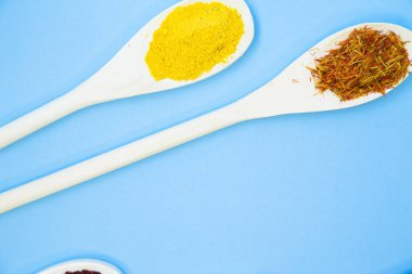 Pişirme sıcak baharatlı yemek kavramı. Kuru baharat ve otlar tahta kaşıklar, açık mavi renkli, yakın çekim, görünümü top