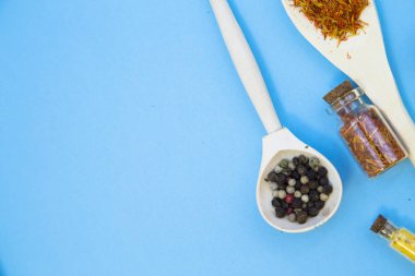 Pişirme sıcak baharatlı yemek kavramı. Tahta kaşık ve cam kavanoz mantar bir ışık mavi backhround, üstten görünüm, Tarih ile Kuru baharat alanı Kopyala