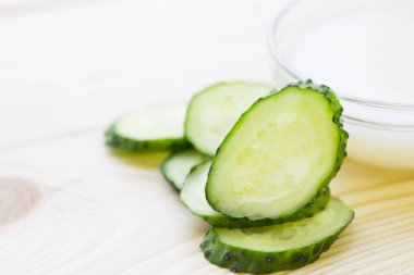 Salatalık ev spa ve saç bakım kavramı. Dilimlenmiş salatalık. Beyaz tahta arka plan. Portre