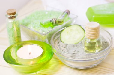 Salatalık ev spa ve saç bakım kavramı. Dilimlenmiş salatalık, yağ, deniz tuzu, banyo havlu şişe. Beyaz tahta arka plan. Portre