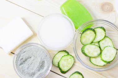 Salatalık ev spa ve saç bakım kavramı. Dilimlenmiş salatalık, yağ, deniz tuzu, banyo havlu şişe. Beyaz tahta arka plan. Portre