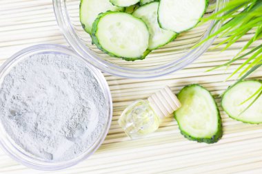 Salatalık ev spa ve saç bakım kavramı. Dilimlenmiş salatalık, yağ, deniz tuzu, banyo havlu şişe. Beyaz tahta arka plan. Portre