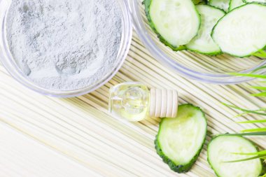 Salatalık ev spa ve saç bakım kavramı. Dilimlenmiş salatalık, yağ, deniz tuzu, banyo havlu şişe. Beyaz tahta arka plan. Portre