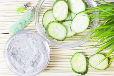 Salatalık ev spa ve saç bakım kavramı. Dilimlenmiş salatalık, yağ, deniz tuzu, banyo havlu şişe. Beyaz tahta arka plan. Portre