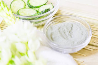 Salatalık ev spa ve saç bakım kavramı. Dilimlenmiş salatalık, yağ, deniz tuzu, banyo havlu şişe. Saman açık renkli. Portre