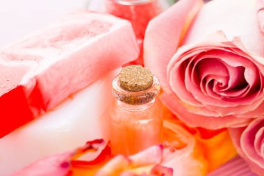 Spa ve sağlıklı yaşam ayarı ile gül çiçek, deniz tuzu, bir şişe ahşap beyaz arka plan üzerinde yağda