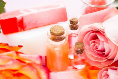 Spa ve sağlıklı yaşam ayarı ile gül çiçek, deniz tuzu, bir şişe ahşap beyaz arka plan üzerinde yağda