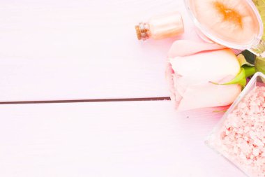 Spa ve sağlıklı yaşam ayarı ile gül çiçek, deniz tuzu, bir şişe ahşap beyaz arka plan üzerinde yağda