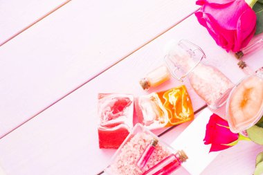 Spa ve sağlıklı yaşam ayarı ile gül çiçek, deniz tuzu, bir şişe ahşap beyaz arka plan üzerinde yağda