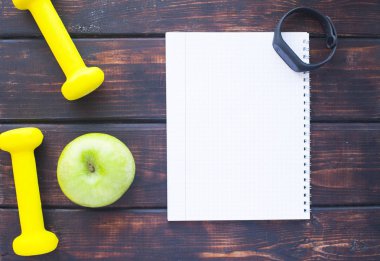 Diyet zayıflama kilo kaybı kavramı zamanı. Spor fitness, elma, spor ayakkabıları, koyu ahşap zemin üzerine su ve sarı ağırlıkları şişe. Vintage retro instagram filtre