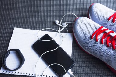 Diyet Zayıflama kilo kaybı kavramı zamanı. Spor, fitness, elma, spor ayakkabı, şişe su ve sarı ağırlıkları gri kauçuk zemin üzerine