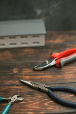 Onarım modern araçlar: koyu ahşap arka plan, üstten görünüm, kopya alanı scisors ve oyuncak ev