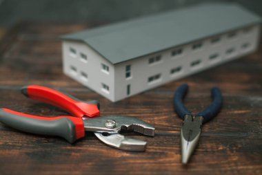 Onarım modern araçlar: koyu ahşap arka plan, üstten görünüm, kopya alanı scisors ve oyuncak ev