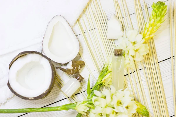 Natural herbal skin care products, top view ingredients coconut, essence oil and flower concept of the best all natural face moisturizer. Facial treatment preparation background