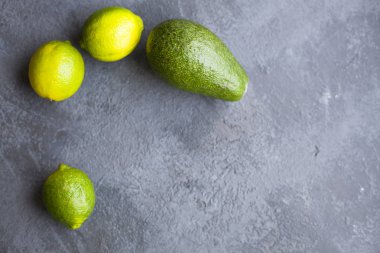 Heathy gıda vejetaryen kavramı. Avokado ve yeşil limes kopya alanı, üstten görünüm karanlık bir beton zemin üzerine