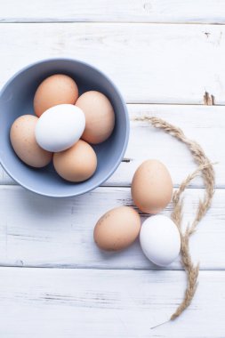 Homamde pasta, pastane kavramı. Organik tavuk yumurtası mavi kase ve bir beyaz tahta masada görünümü top