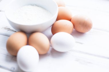 Homamde pasta, pastane kavramı. Buğday unu ve organik tavuk yumurtası Beyaz ahşap bir masa üzerinde bir kase