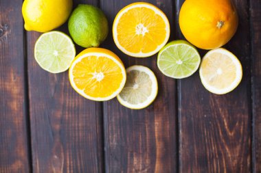 Meyve çayı, kokteyl, tatlı kavramı. Top kesim ve bütün taze portakal, limon ve limes bir koyu ahşap Tablo görünümü