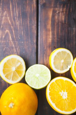 Meyve çayı, kokteyl, tatlı kavramı. Top kesim ve bütün taze portakal, limon ve limes bir koyu ahşap Tablo görünümü