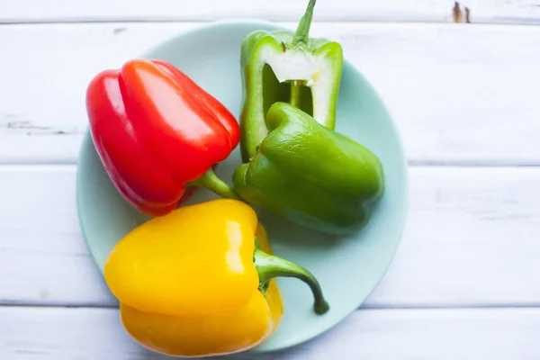 健康食品 素食概念 黄色和绿色的辣椒粉辣椒在一个蓝色的盘子 白色的木制背景 顶视图 — 图库照片