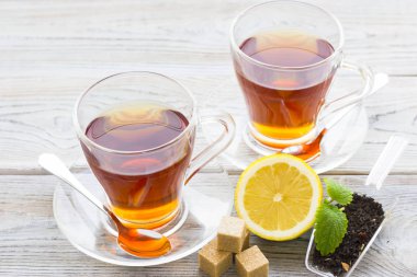 Siyah çay töreni - cam çay, çay yaprakları, şeker, sarı limon, tam bir ahşap kurulları zemin üzerine baharat. Üstten görünüm