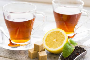 Siyah çay töreni - cam çay, çay yaprakları, şeker, sarı limon, tam bir ahşap kurulları zemin üzerine baharat. Üstten görünüm