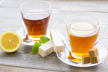 Siyah çay töreni - cam çay, çay yaprakları, şeker, sarı limon, tam bir ahşap kurulları zemin üzerine baharat. Üstten görünüm