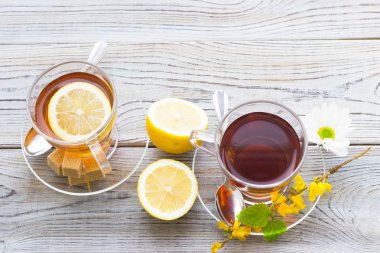 Siyah çay töreni - cam çay, çay yaprakları, şeker, sarı limon, tam bir ahşap kurulları zemin üzerine baharat. Üstten görünüm